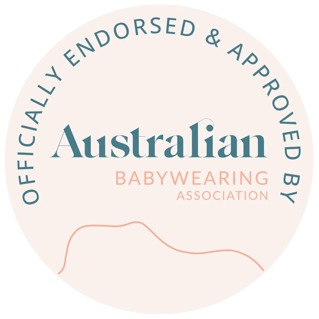 A circular badge with a pale blush background reading 'OFFICIALLY ENDORSED & APPROVED BY Australian Babywearing Association' in teal and peach text, with a simple peach line drawing near the bottom.