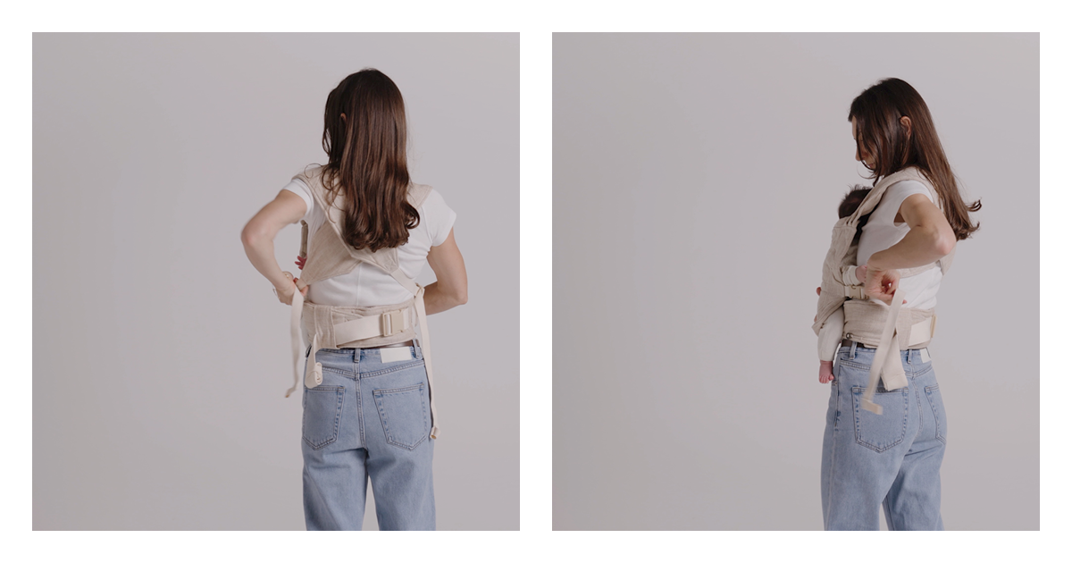 Mum pulling the excess webbing through the clip to tighten the Daily baby carrier straps, newborn held close