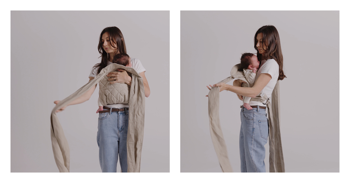 Mum bringing the quilted panel up over her newborn's back and taking a long linen strap out to the side