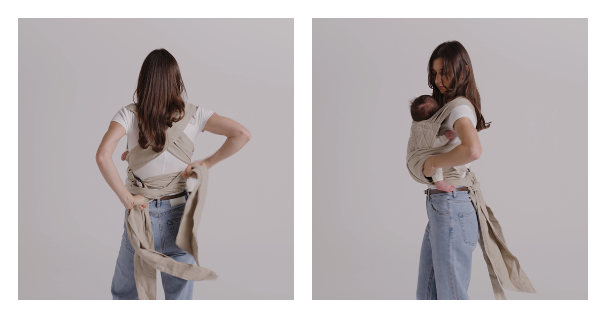 Mum tying the Wrap Carrier straps off behind her back with her newborn settled against her chest